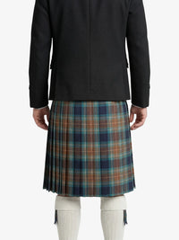 Person wearing a black jacket and plaid kilt on a white background