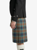 Person wearing a black jacket and plaid kilt on a white background