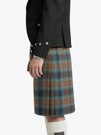 Person wearing a black jacket and plaid kilt on a white background