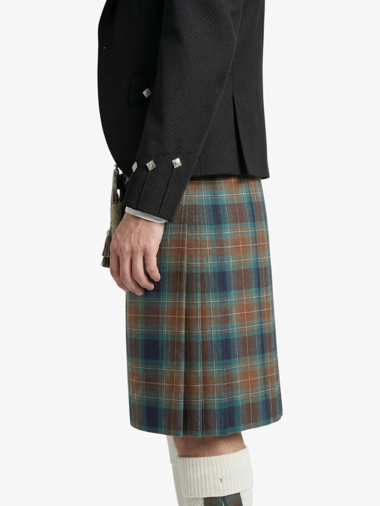 Person wearing a black jacket and plaid kilt on a white background