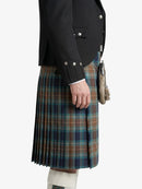 Person wearing a black jacket and plaid kilt on a white background