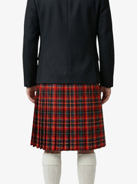 Person wearing a black coat and red plaid kilt on a white background