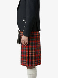 Person wearing a dark jacket and red plaid kilt on a white background
