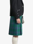Person wearing a black jacket and green plaid kilt on a white background