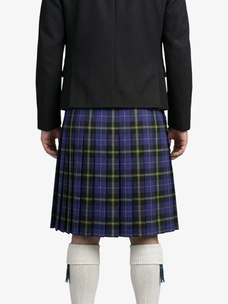 Person wearing a black jacket and blue plaid kilt on a white background