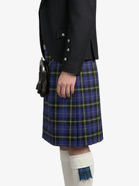 Person wearing a black jacket and blue plaid kilt on a white background