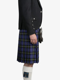 Person wearing a dark jacket and blue plaid kilt on a white background