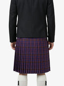 Person wearing a black jacket and plaid kilt on a white background