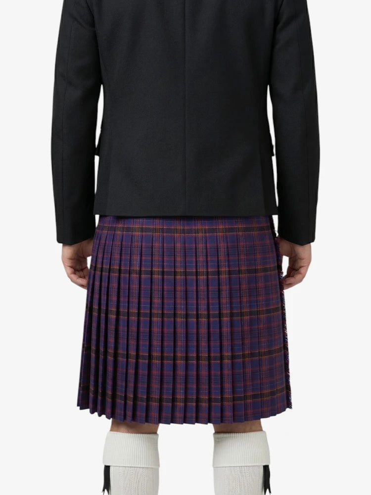 Person wearing a black jacket and plaid kilt on a white background