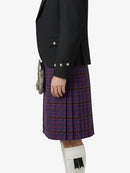 Person wearing a black blazer and red plaid kilt on a white background