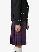 Person wearing a black jacket and plaid kilt on a white background
