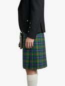 Person wearing a black jacket and green plaid kilt on a white background