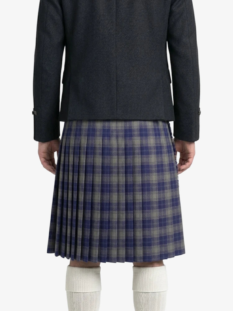 Person wearing a dark gray jacket and plaid kilt on a white background 