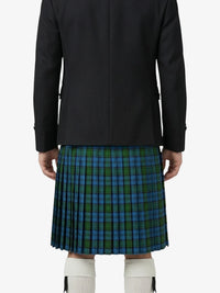 Person wearing a black jacket and green plaid kilt on a white background