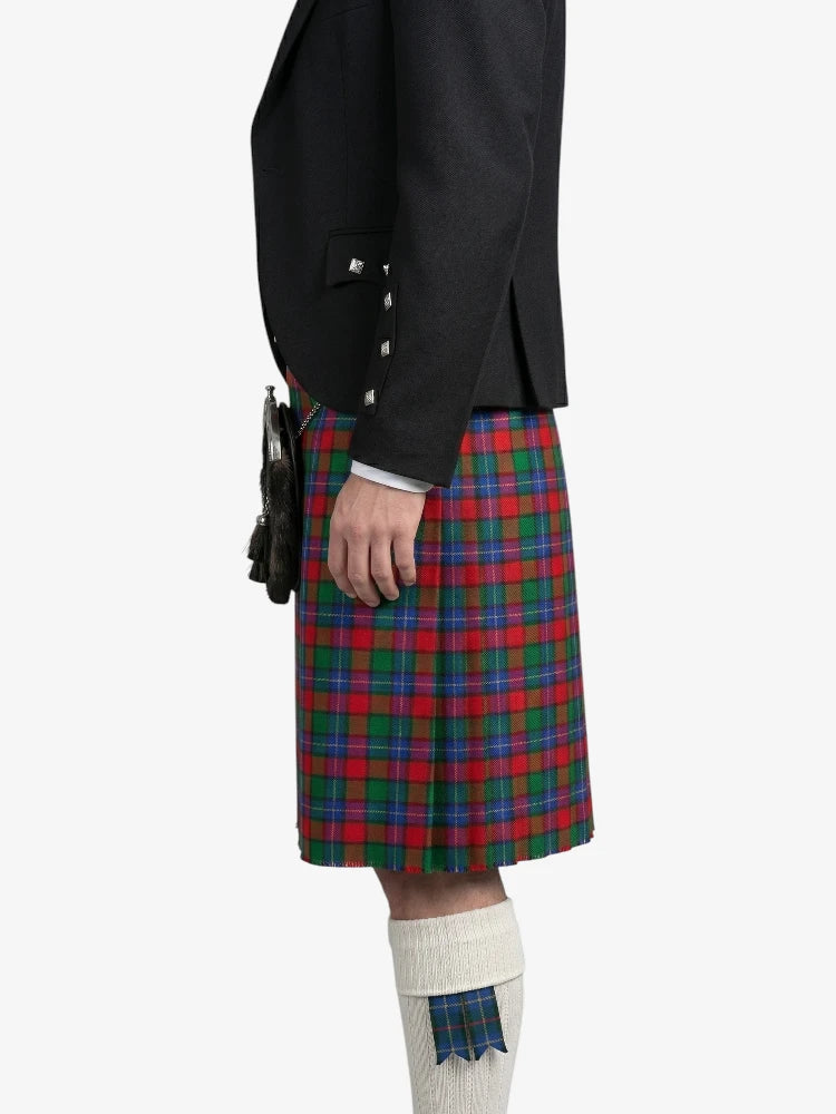 Person wearing a black jacket and red, green, and blue plaid kilt on a white background
