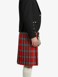 Person wearing a black jacket and red plaid kilt on a white background