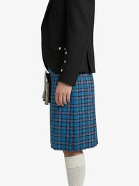 Person wearing a black jacket and blue plaid kilt on a white background