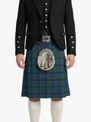 Person wearing a traditional Scottish kilt with a tartan pattern on a white background
