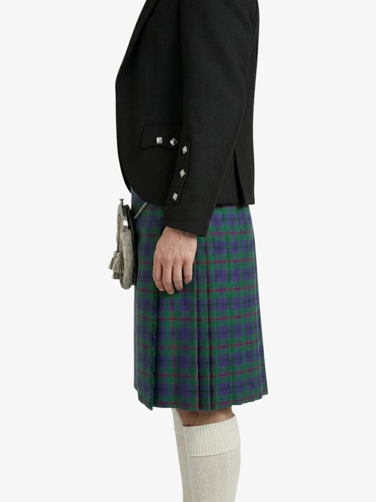 Person wearing a black jacket and green plaid kilt on a white background
