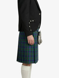 Person wearing a black blazer and green plaid kilt on a white background