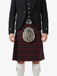 Person wearing a traditional Scottish kilt with a tartan pattern on a white background