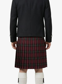 Person wearing a black jacket and red plaid kilt on a white background