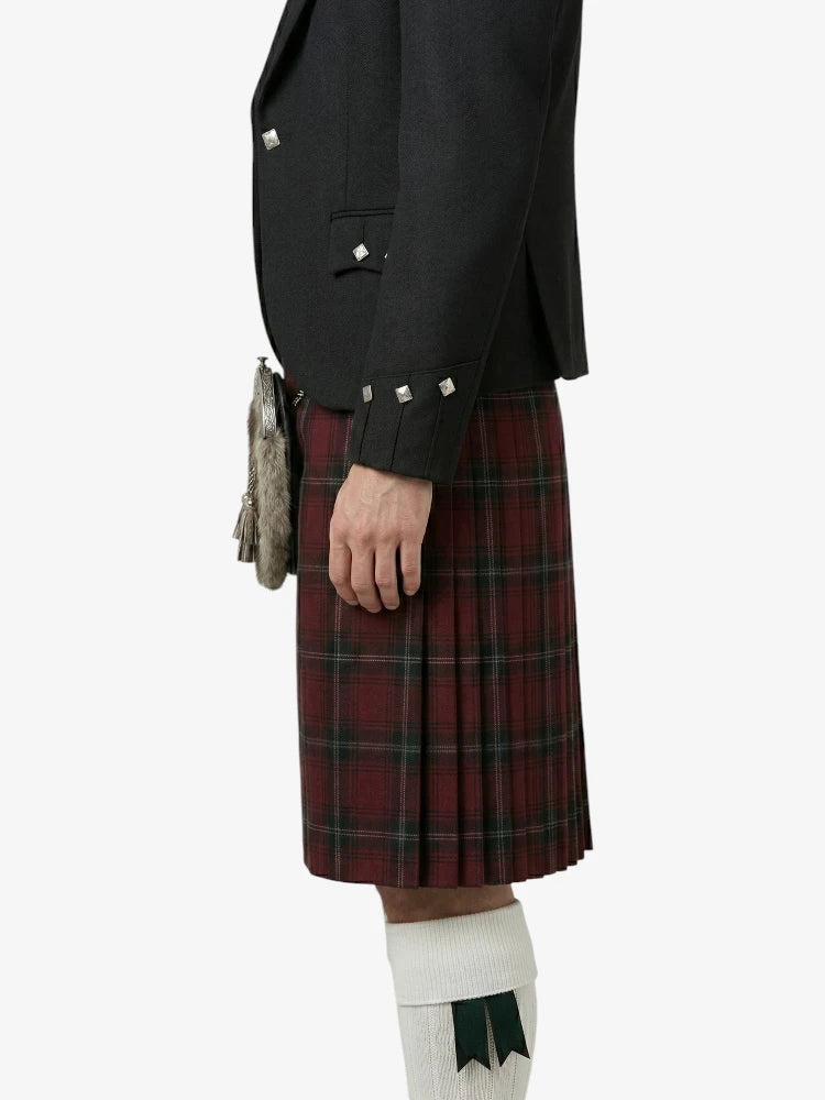 Person wearing a black jacket and red tartan kilt on a white background