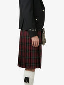 Person wearing a black jacket and red plaid kilt on a white background