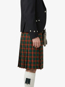 Person wearing a black jacket and green plaid kilt on a white background