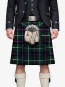 Person wearing a traditional Scottish kilt with a tartan pattern on a white background