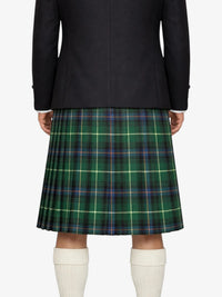 Person wearing a black jacket and green plaid kilt on a white background