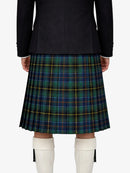 Person wearing a black jacket and green plaid kilt on a white background