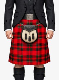 Person wearing a red tartan kilt with a black jacket and knee-high boots on a white background