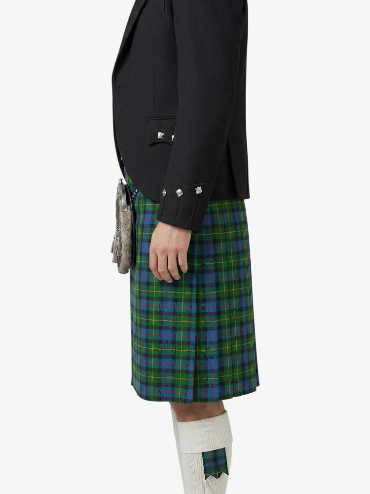Person wearing a black jacket and green plaid kilt on a white background