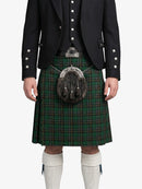 Person wearing a traditional Scottish kilt with a dark jacket on a white background