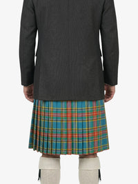 Person wearing a dark jacket and a colorful plaid kilt on a white background