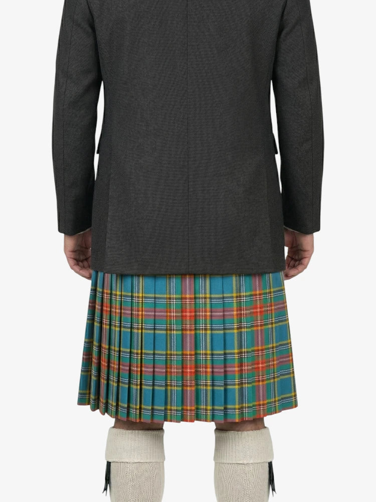 Person wearing a dark jacket and a colorful plaid kilt on a white background