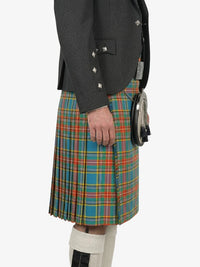 Person wearing a dark gray jacket and a colorful plaid kilt on a white background