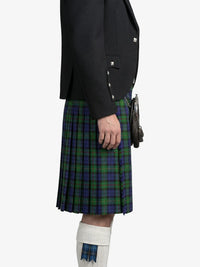 Person wearing a black jacket and green plaid kilt on a white background