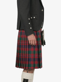 Person wearing a black jacket and red plaid kilt on a white background