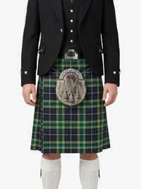 Person wearing a traditional Scottish kilt with a tartan pattern on a white background