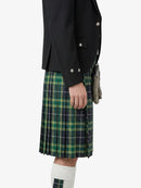 Person wearing a black jacket and green plaid kilt on a white background