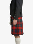 Person wearing a black jacket and red plaid kilt on a white background