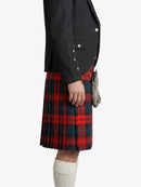 Person wearing a black jacket and red plaid kilt on a white background