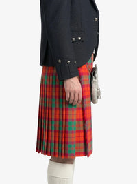 Person wearing a red plaid kilt with a dark jacket on a white background