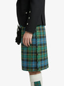 Person wearing a green plaid kilt with a black jacket on a white background