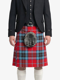 Person wearing a red plaid kilt with a black jacket on a white background