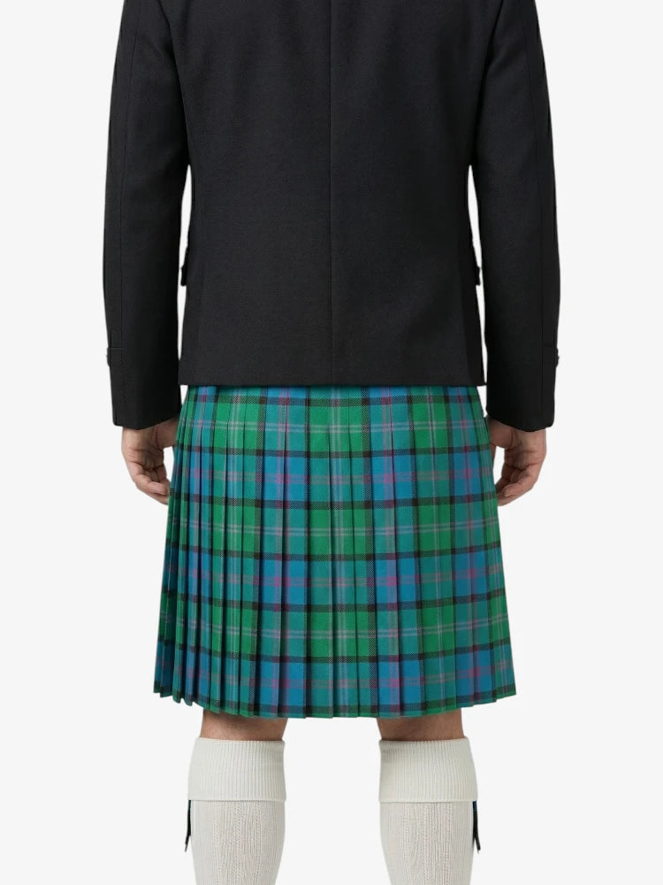 Person wearing a black jacket and green plaid kilt on a white background