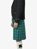 Person wearing a black jacket and green plaid kilt on a white background