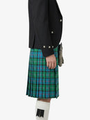 Person wearing a black jacket and green plaid kilt on a white background